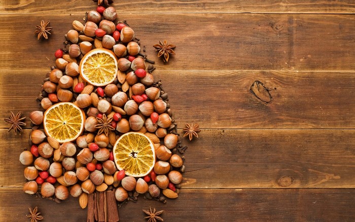 Christmas tree made of nuts and dried oranges on wood