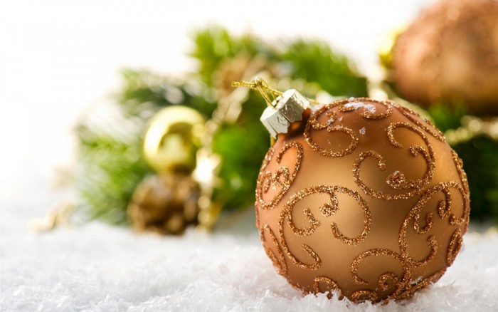 Close-up of a golden Christmas ornament on snow