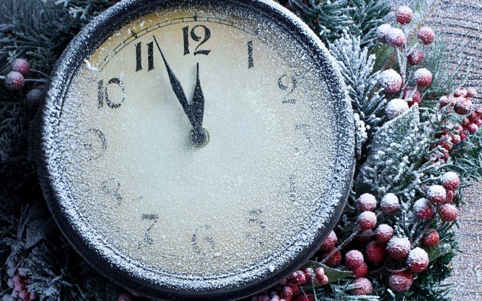 Close-up of a frosted clock with Christmas wreath