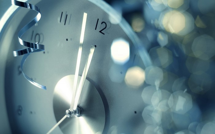 Close-up of a clock with a ribbon and bokeh lights