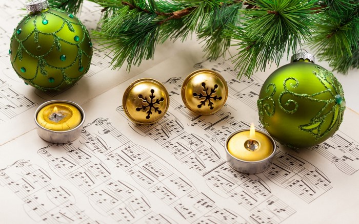 Christmas ornaments and candles on sheet music