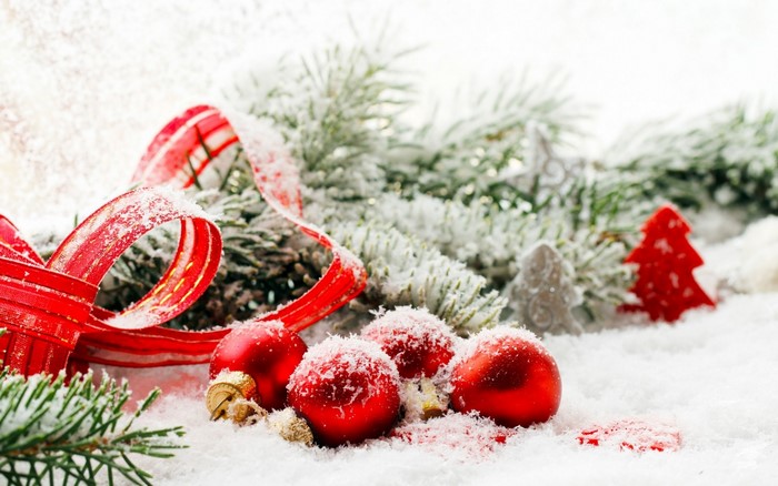 Christmas ornaments and ribbon on snow-covered fir branches