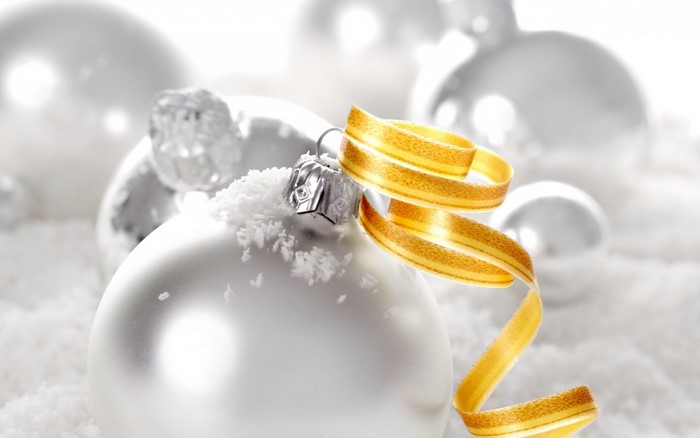 Close-up of a white Christmas ornament with a yellow ribbon