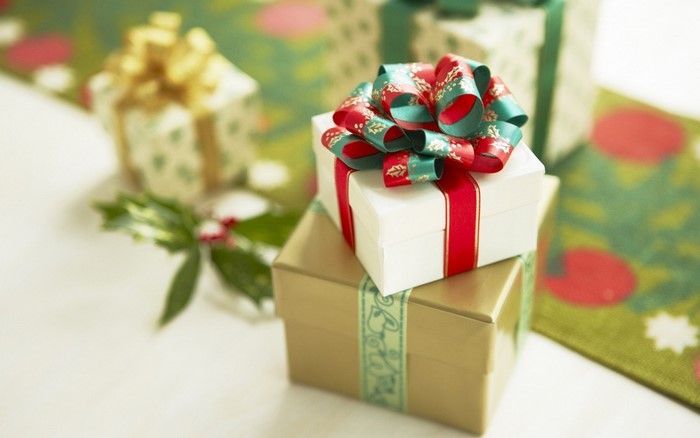 Christmas gifts with red and green ribbons and holly