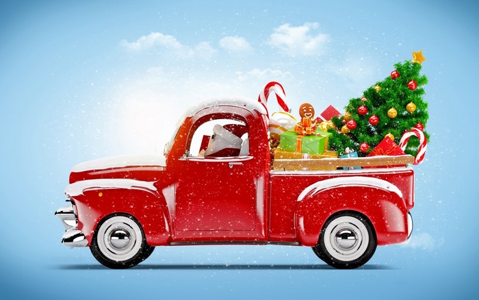 Red vintage pickup truck filled with Christmas gifts and tree