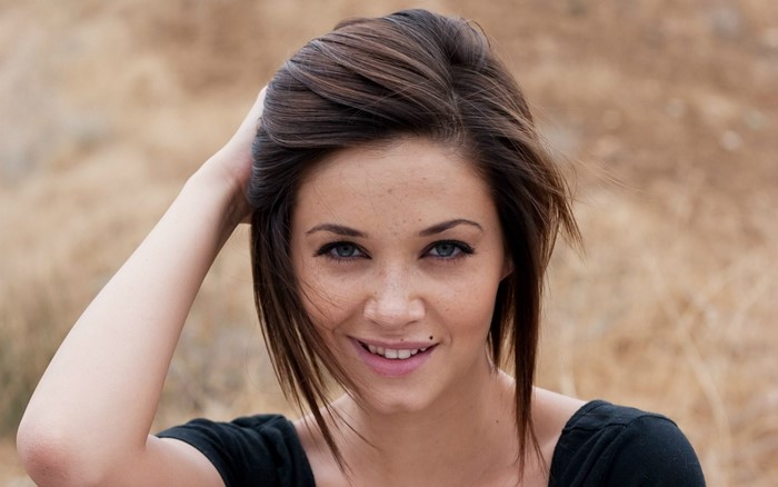 Woman with brown hair and blue eyes smiling