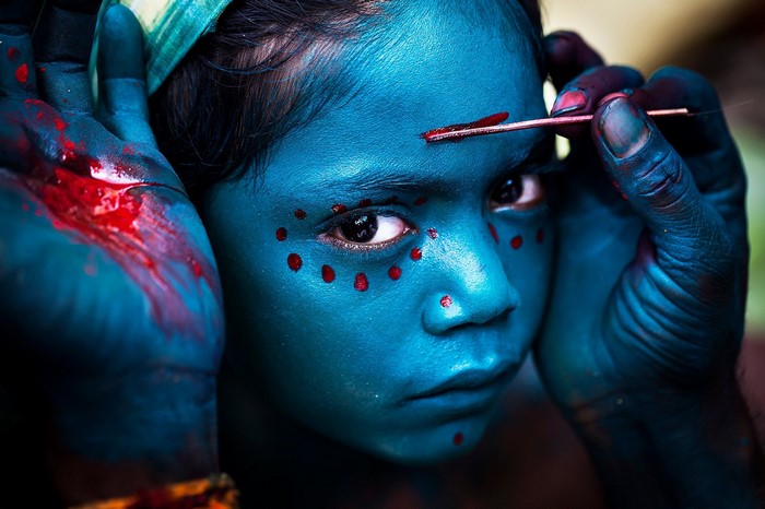 Child with blue face paint and red dots