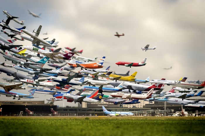 A multitude of airplanes in the sky over an airport
