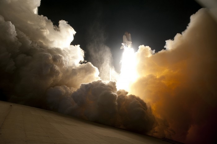 Space shuttle launch with massive smoke plume
