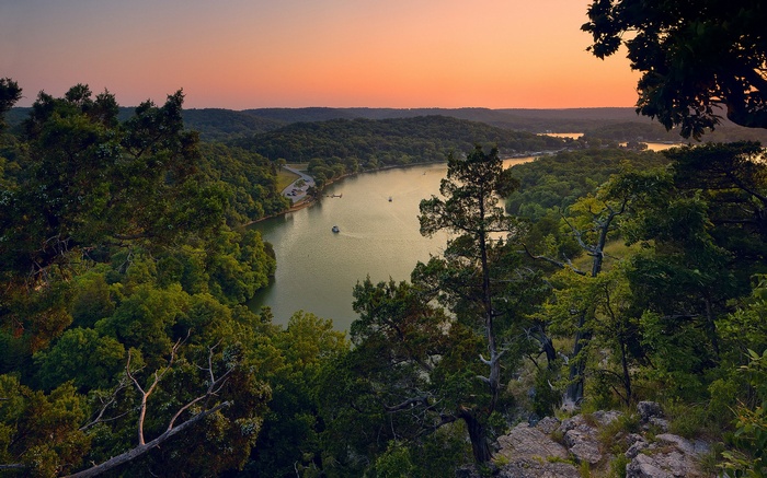 Sunset over a winding river and forested hills