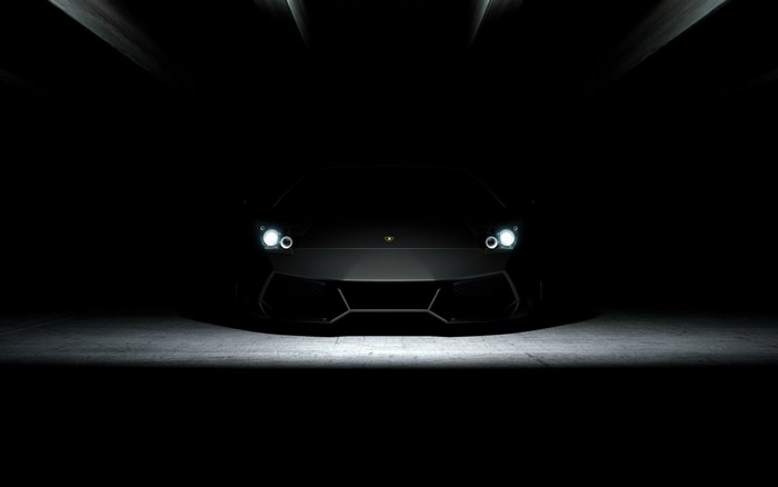 Black Lamborghini sports car in a dark setting