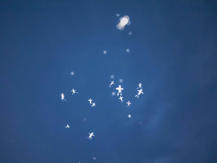 Abstract figures in a dark blue sky