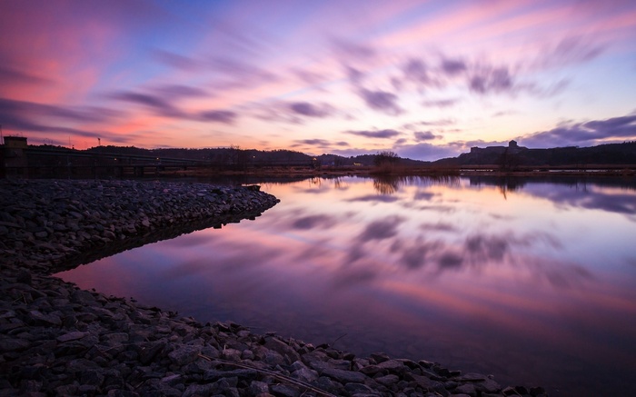 Sunset over a rocky lake with colorful clouds
