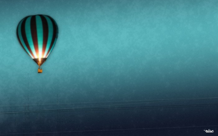 Hot air balloon with teal and black stripes against a gradient sky