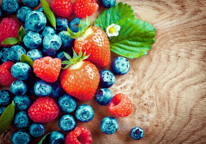 Berries and strawberries on a wooden surface