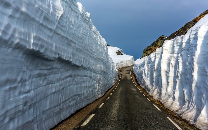 Road through snow walls in mountains
