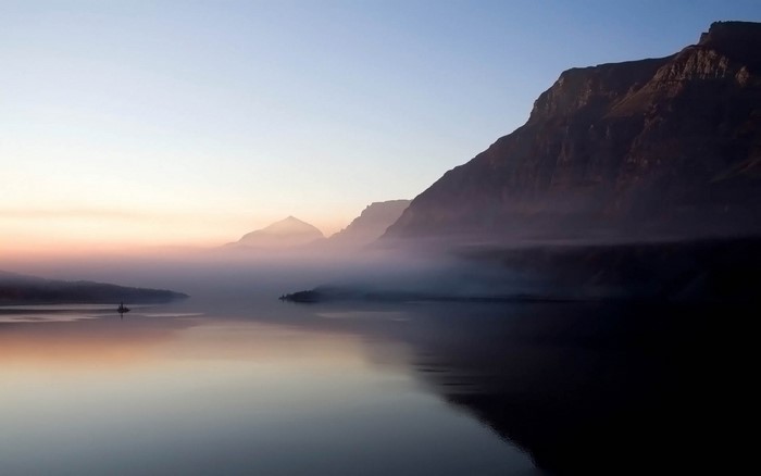 Misty lake and mountains at sunrise