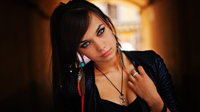 Woman with dark hair and feather earrings