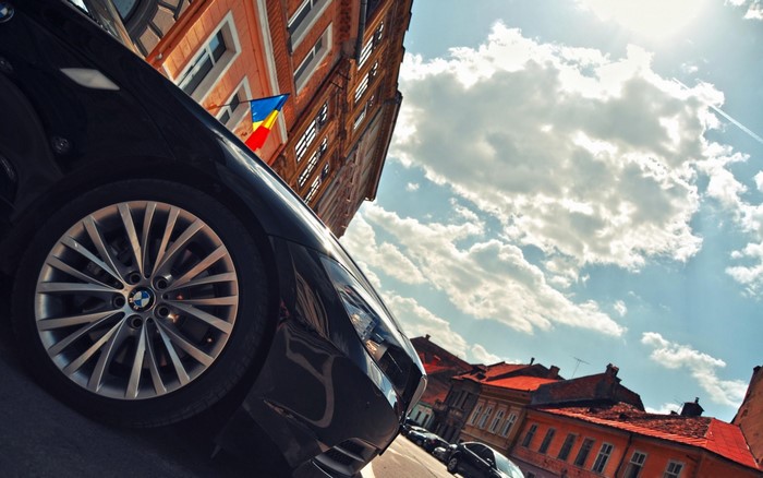 Black BMW Z4 with Romanian Flag on Building