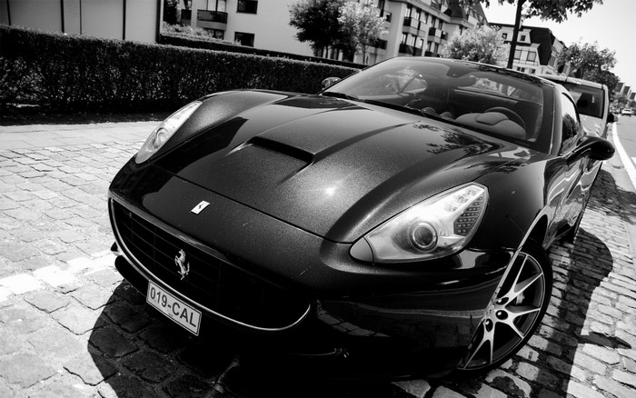 Black Ferrari California Convertible on Cobblestone Street