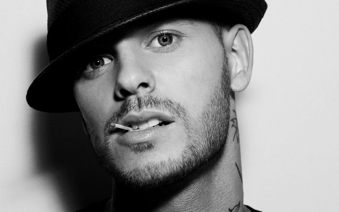 Man wearing a hat with a match in his mouth