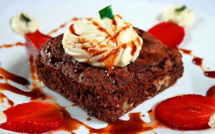 Chocolate brownie with whipped cream and strawberries