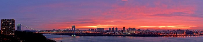 Panoramic sunset over New York City skyline and bridge