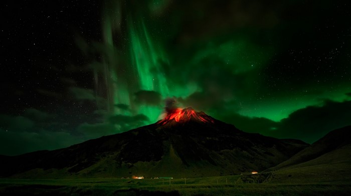 Volcano erupting under Aurora Borealis at night