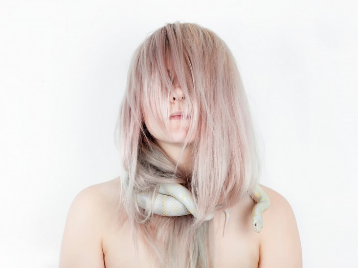 Woman with pink hair and a snake around her neck