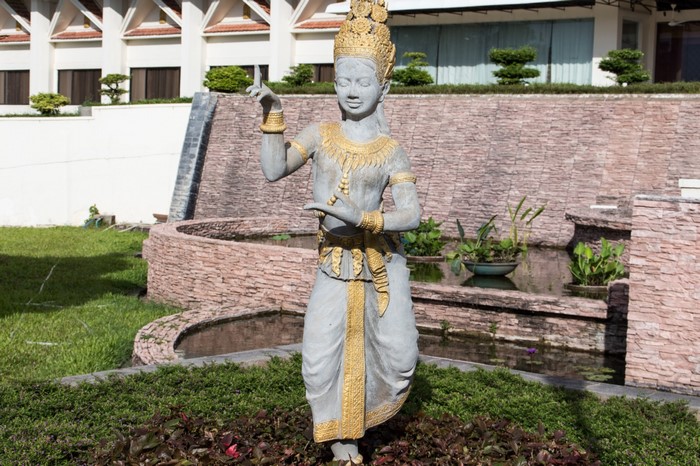 Stone sculpture of a dancer in a garden