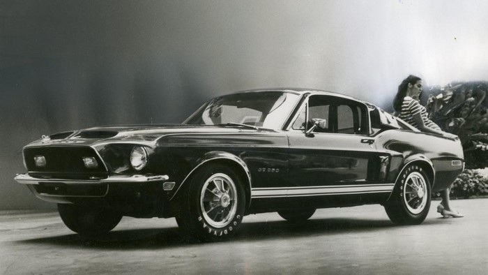 Woman leaning on a 1968 Shelby GT350 Mustang