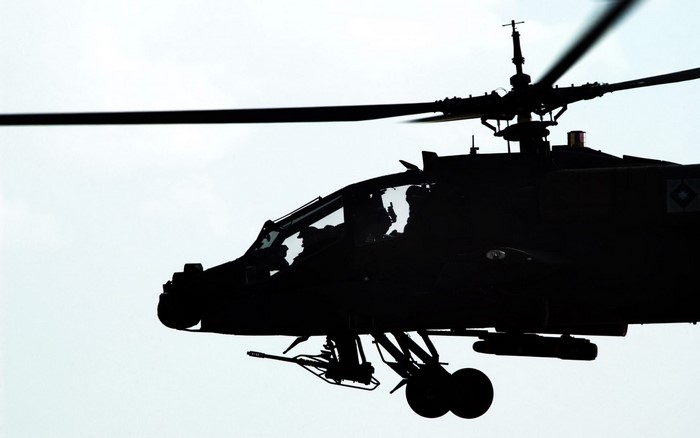 Silhouette of an AH-64 Apache military helicopter in flight