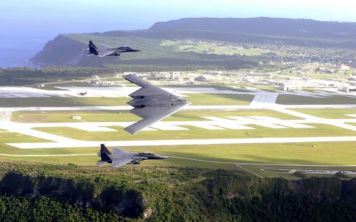 B-2 Spirit and F-15 Eagles fly over an airfield
