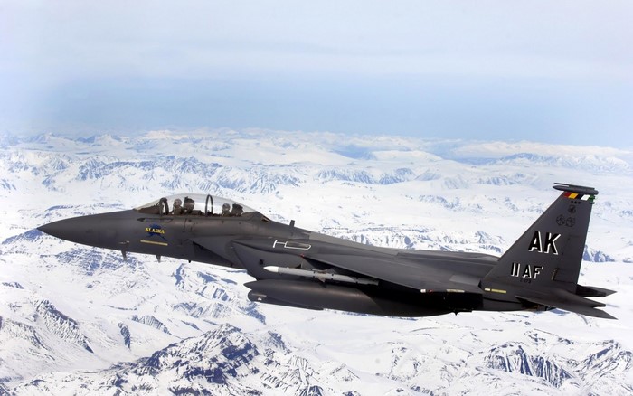 McDonnell Douglas F-15 Eagle fighter jet flying over snowy mountains