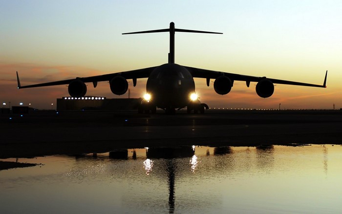 Silhouette of a military cargo plane at sunset