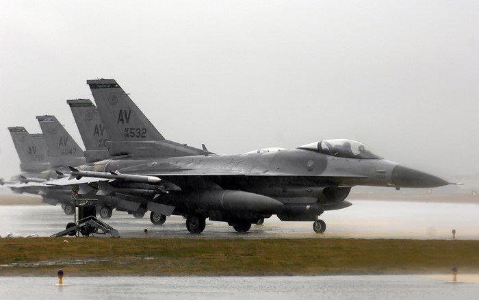 F-16 Fighting Falcon fighter jets on a wet tarmac