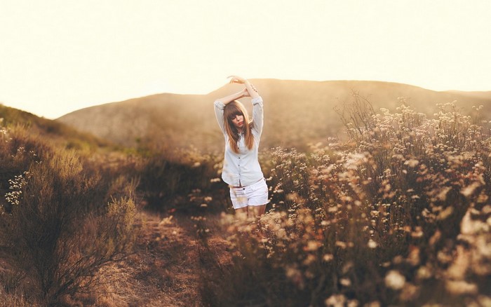 Woman with arms up in a field of flowers