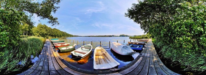 Boats docked at a wooden pier on a lake