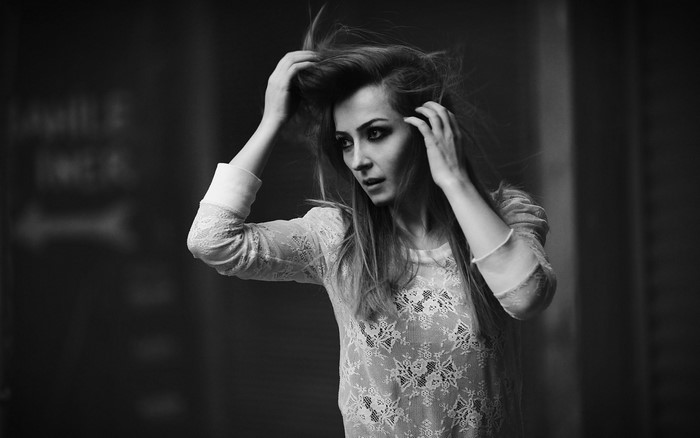 Monochrome portrait of a woman with hands in her hair