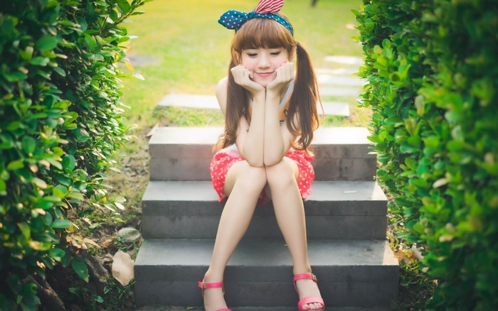 Young Asian woman with pigtails sitting on steps