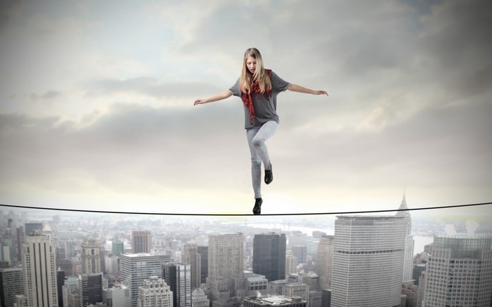 Woman tightrope walking over a city