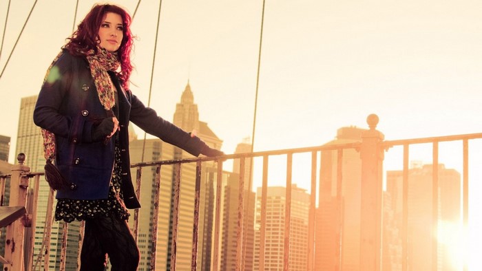 Susan Coffey on a bridge with city skyline