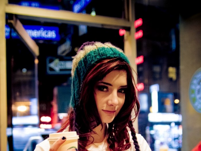 Susan Coffey wearing a colorful hat holding a coffee cup