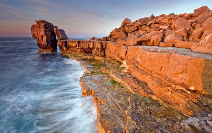 Coastal rock formations with waves crashing on shore