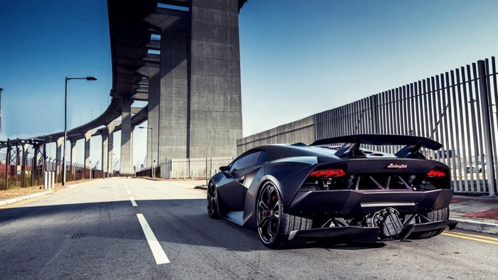 Black Lamborghini Sesto Elemento on a Road Under a Bridge