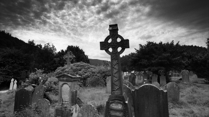 Monochrome cemetery with Celtic cross and gravestones