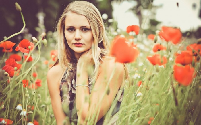 Young woman in a poppy field