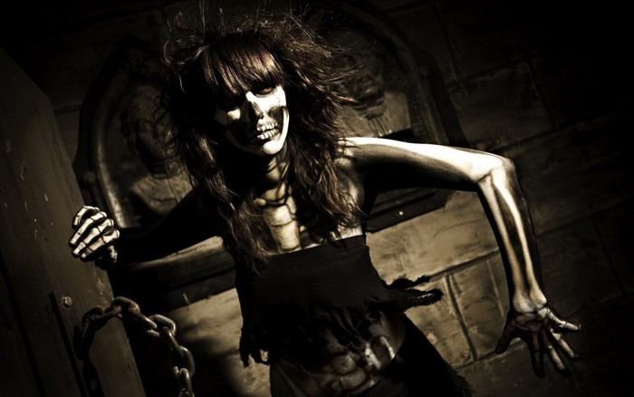 Woman with skeleton makeup in dark room