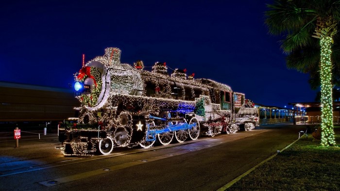 Steam locomotive decorated with Christmas lights at night