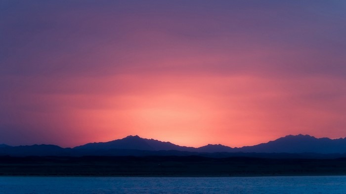 Sunset over mountains and water